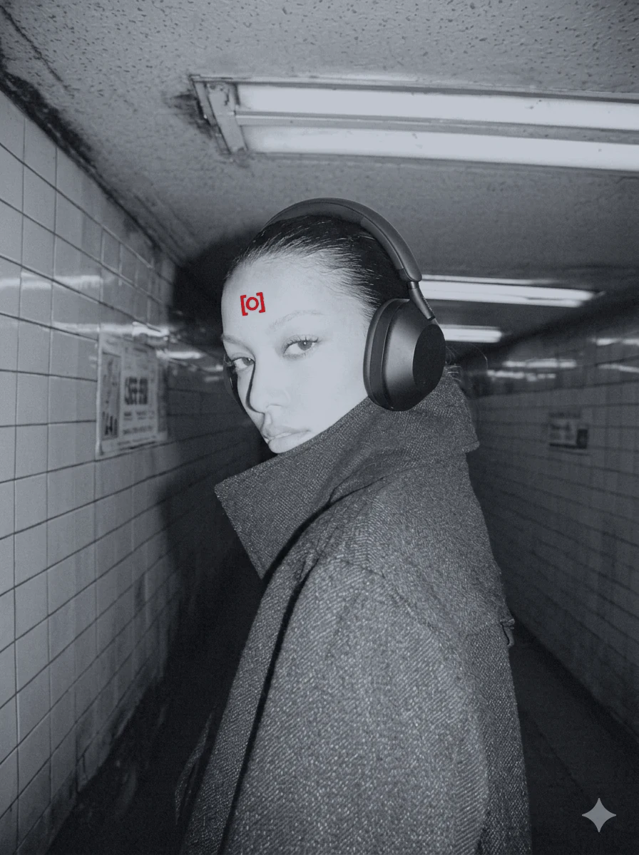 Portrait in a subway tunnel wearing over-ear headphones, cool desaturated tone with a crimson KAGE forehead mark.